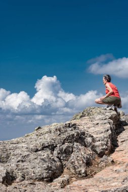 Dağın tepesinden vadiye bakan bir kadın
