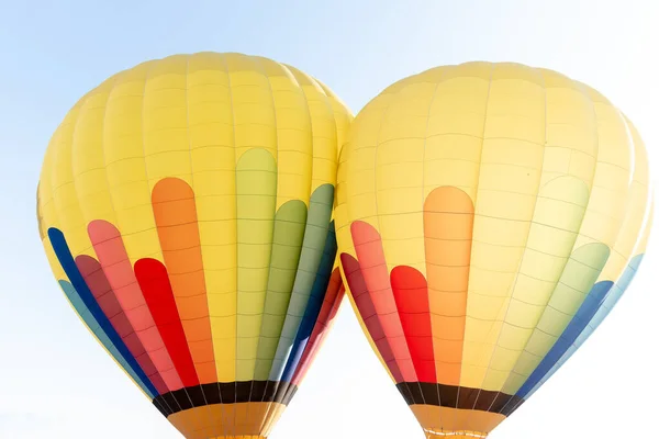 İki hava sıcak balonu yeşil, mavi, kırmızı ve sarı renklerde