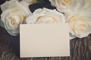 Beyaz yapay gül ile boş tebrik kartı