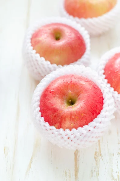 Manzanas rojas en mesa de madera blanca — Foto de Stock