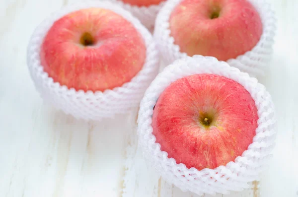 Manzanas rojas en mesa de madera blanca — Foto de Stock