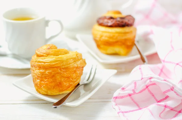 Mini cruffin (croissant och muffin) i vit skål med kopp te — Stockfoto