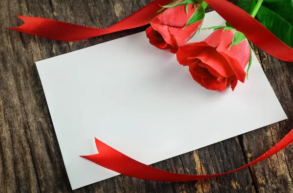 Cartão branco em branco com rosas vermelhas — Fotografia de Stock