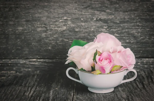 白いカップで人工のバラ — ストック写真