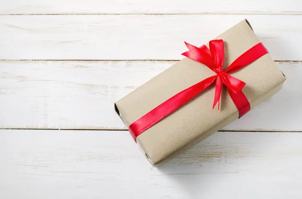 Caja de regalo marrón con lazo de cinta roja — Foto de Stock