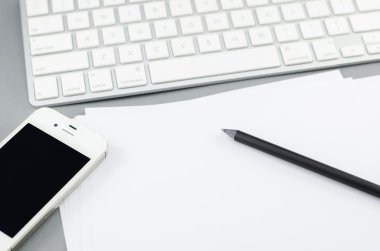 Boş kağıt kalem ve akıllı telefon bilgisayar masası