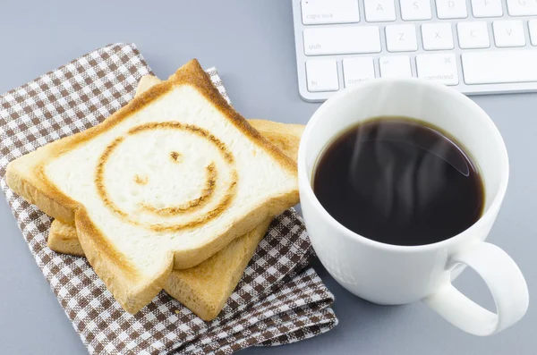 Morgonkaffe och rostat bröd med leende brännmärke — Stockfoto