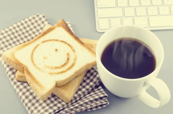 Morning coffee and toasted bread with smiling burn mark