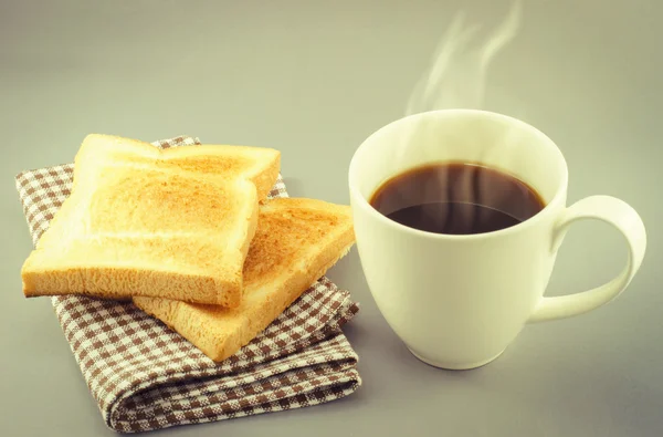 Xícara de café e pão fatiado em guardanapo — Fotografia de Stock