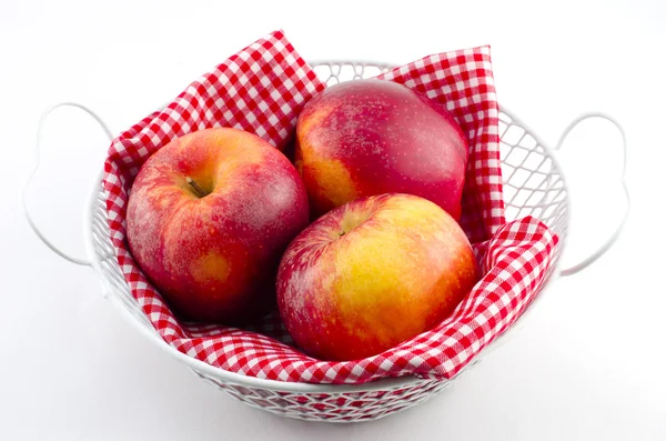 Manzanas con servilleta roja en una canasta blanca — Foto de Stock