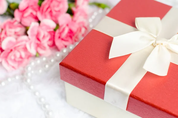 Close up of gift box with pearl necklace and pink carnation flow — Stock Photo, Image