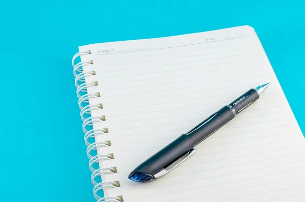 Notebook aperto con penna su sfondo blu — Foto Stock