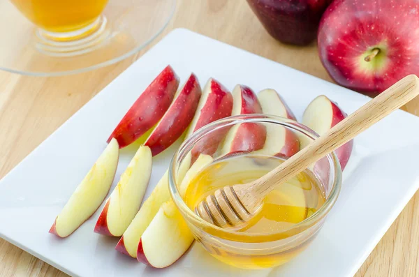 Manzana con miel en plato sobre mesa de madera-Año Nuevo judío — Foto de Stock