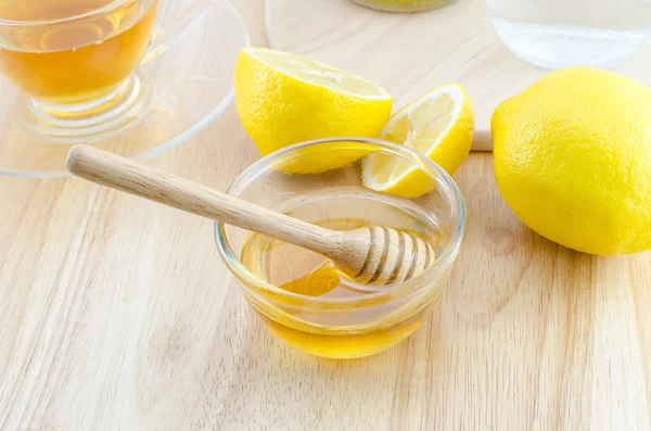 Мед с лимоном на деревянном столе — стоковое фото