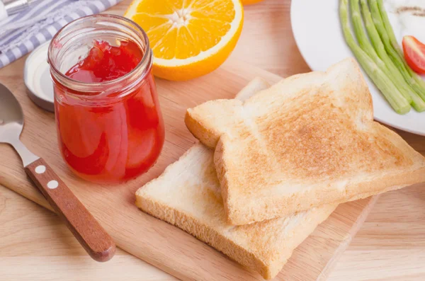 Hälsosam frukost med varma smörgåsar och jordgubbssylt, på trä tabl — Stockfoto