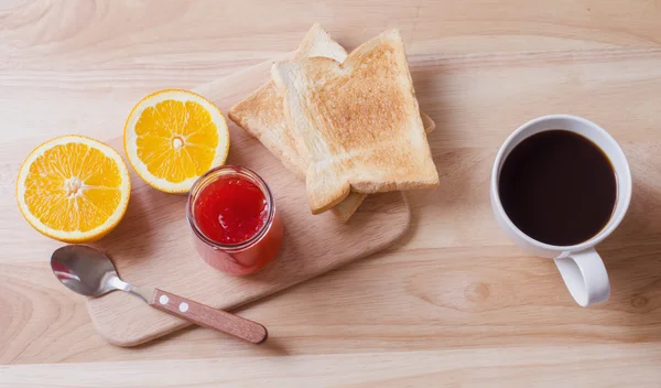 Frukost med kaffe, rostat bröd och jordgubbssylt på träbord — Stockfoto