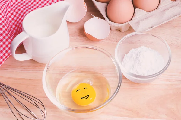 Cookies ingredients. Egg with smilling face in bowl, flour, milk