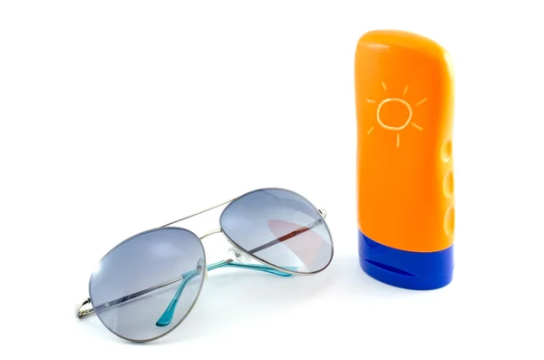 Solglasögon och bodylotion på vit bakgrund — Stockfoto