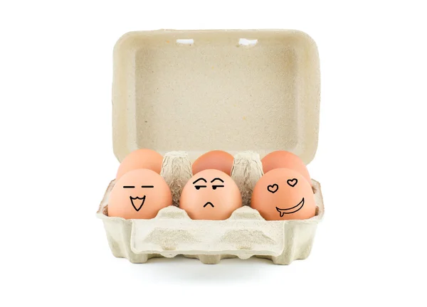 鸡蛋在纸箱上滑稽绘图面临分离对白色带剪辑 图库照片