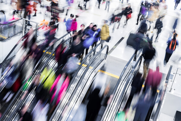 Motion blurred crowded people shopping in mall