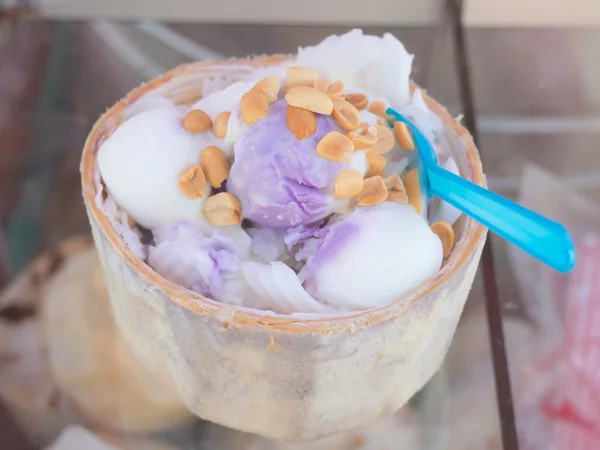 Primo piano del gelato al latte di cocco in guscio di cocco cosparso di noce di cocco — Foto Stock