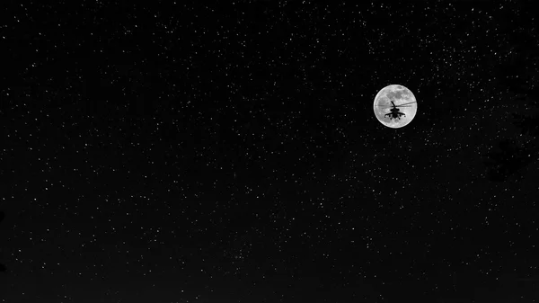 战斗直升机在背景上的月亮和繁星密布的天空 — 图库照片