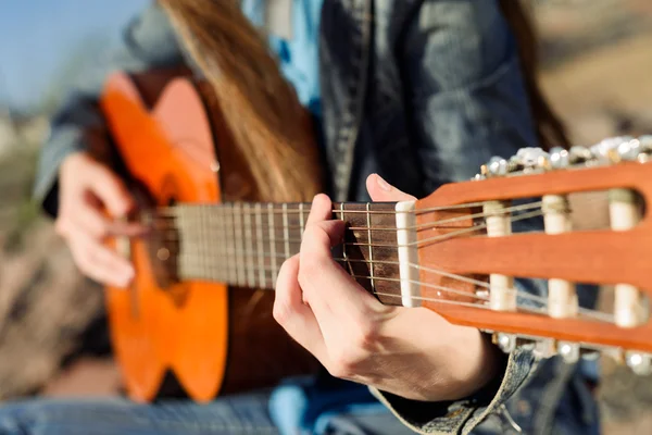 Close up shot without face. Woman playng guitar an the coast — Stock Photo, Image