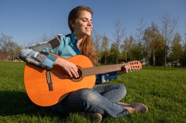 Gitar Park çimenlerin üzerinde açık olan kadın