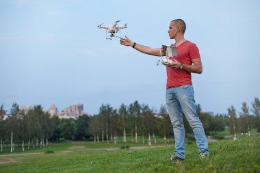 Adam bir quadrocopter Park kontrol eder.