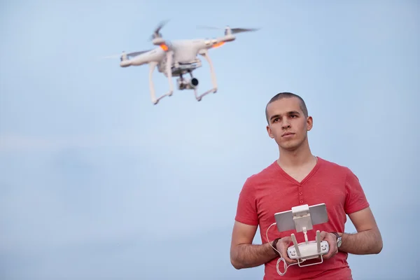 El hombre controla un cuadrohelicóptero. Enfoque selectivo en los hombres, el dron está borroso — Foto de Stock