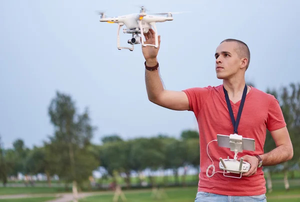 El hombre controla un quadrocopter en el parque — Foto de Stock