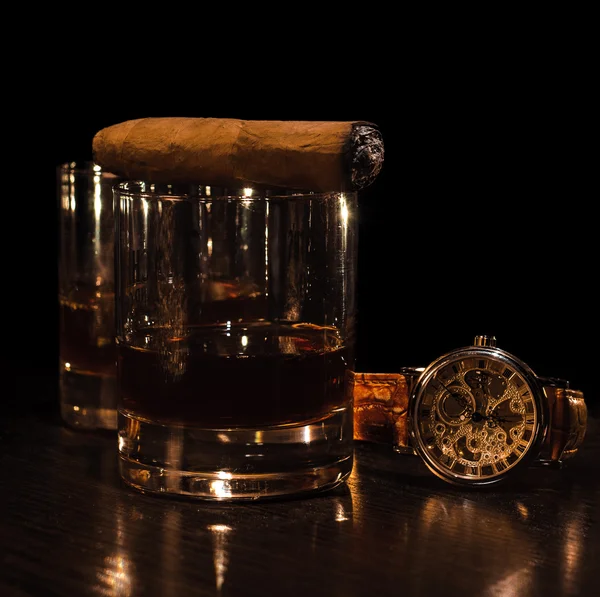 Stillleben mit Cognac, Zigarre und einer Uhr auf einem hölzernen Hintergrund. Luxus — Stockfoto