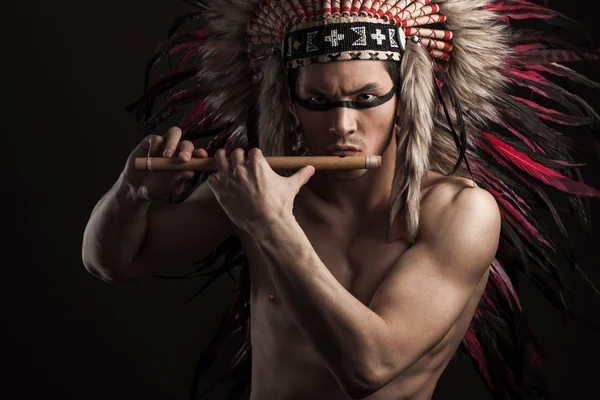 Porträt des indischen starken Mannes, der mit traditionellem indianischem Make-up posiert. Flöte spielen — Stockfoto