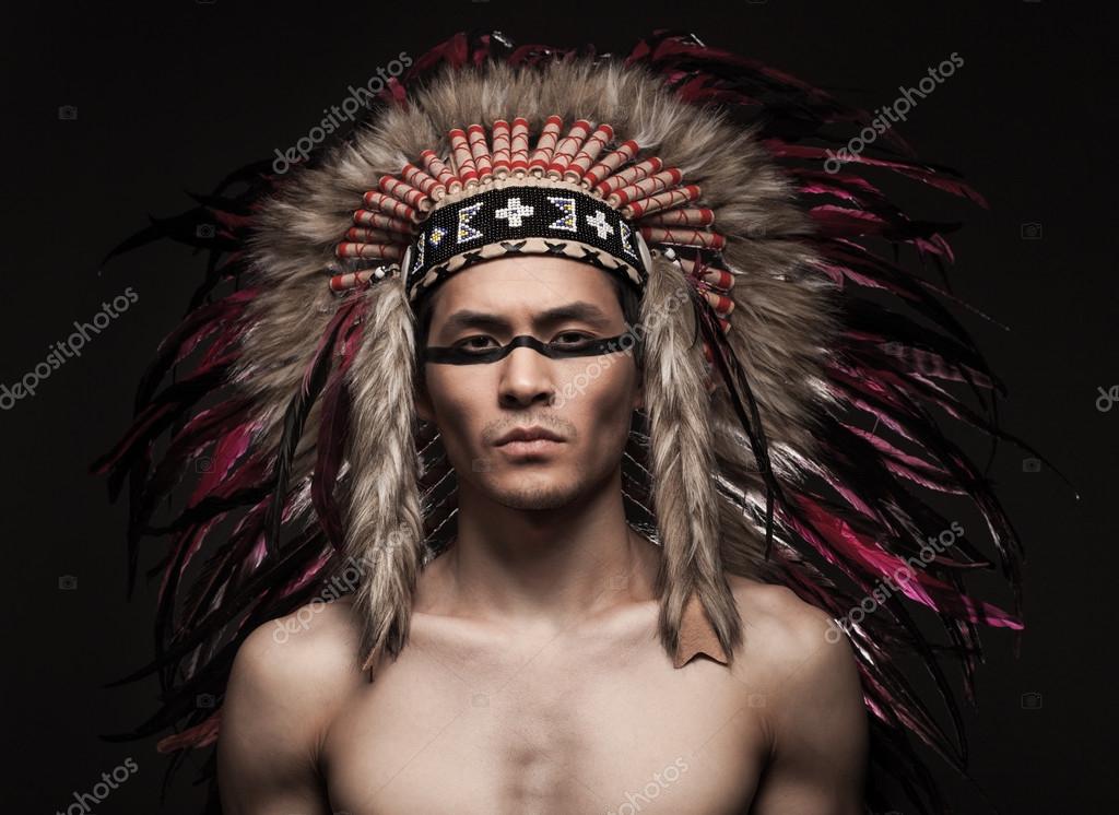 Portrait of the indian strong man posing with traditional native american make up Stock Photo by