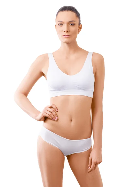 Wanita dengan tubuh langsing yang cantik berpose dalam pakaian di latar belakang putih — Stok Foto