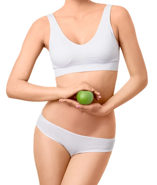 Тонкая женщина в белых трусах с зеленым яблоком на руках на изолированном фоне — стоковое фото