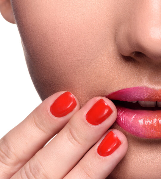 Часть лица. Чувственная молодая женщина с красочным макияжем губ и красными ногтями
