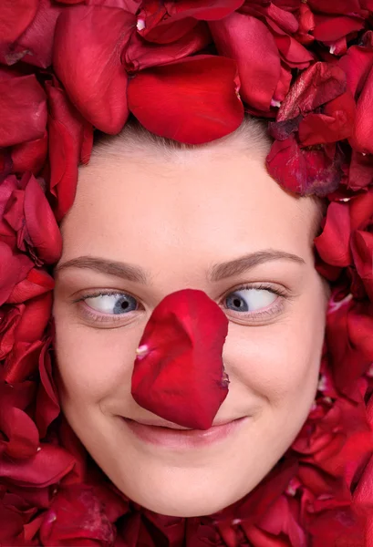Mujer divertida acostada en pétalo de rosas — Foto de Stock