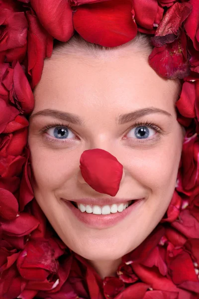 Hermosa mujer feliz acostada en rosas pétalos — Foto de Stock