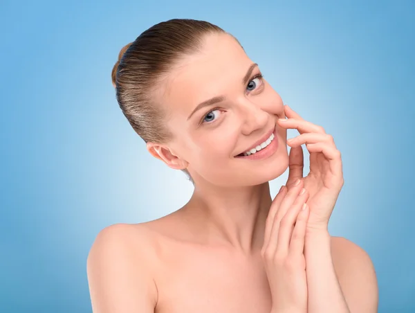 Linda cara de mulher olhando para a câmera sobre fundo azul . — Fotografia de Stock