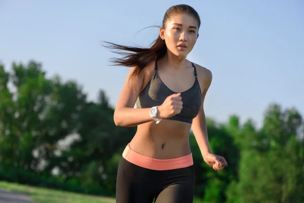 Junge asiatische Frau joggt im Park — Stockfoto