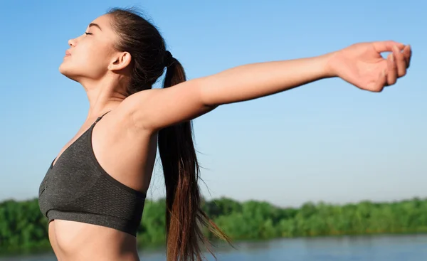 Glückliche asiatische Frau hebt die Arme in den Himmel. — Stockfoto