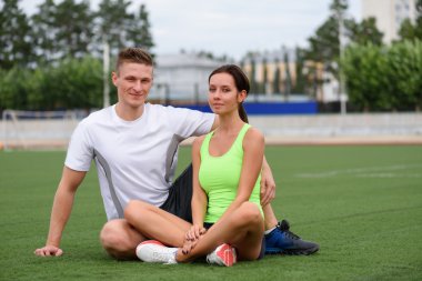 Stadyumda eğitim fitness spor sonra Çimenlikte oturan Çift