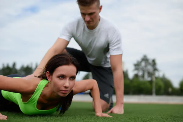 Kaukasisches Paar trainiert auf Rasen im Stadion — Stockfoto