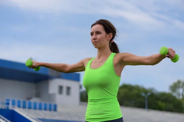 Entrenamiento de mujer fitness con mancuerna en el staduim —  Fotos de Stock