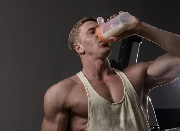 Atleta uomo bere proteine in palestra — Foto Stock