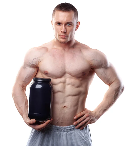 Bodybuilder hält ein schwarzes Plastikgefäß mit Molkenprotein auf weißem Hintergrund — Stockfoto