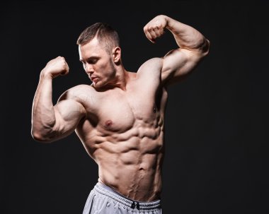 Kasları kas gömleksiz adam koyu arka plan üzerinde Studio gösterir.
