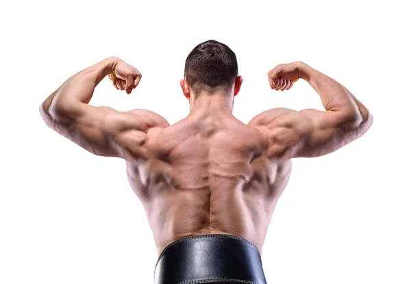 Hombre musculoso en el estudio sobre fondo oscuro muestran su delt y espalda —  Fotos de Stock