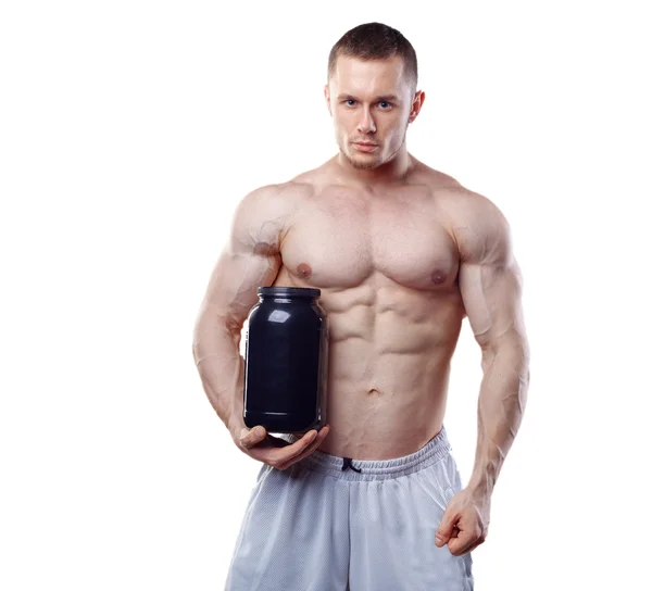 Bodybuilder hält ein schwarzes Plastikgefäß mit Molkenprotein auf weißem Hintergrund — Stockfoto